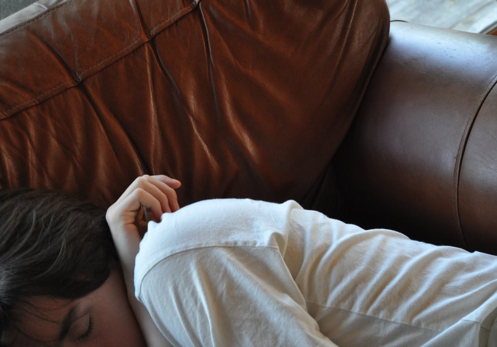 Woman resting on a couch during a daytime nap
