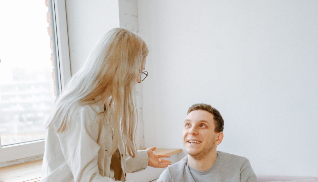 A couple sitting close together, mid-conversation, sharing an open and honest moment about sex and relationships