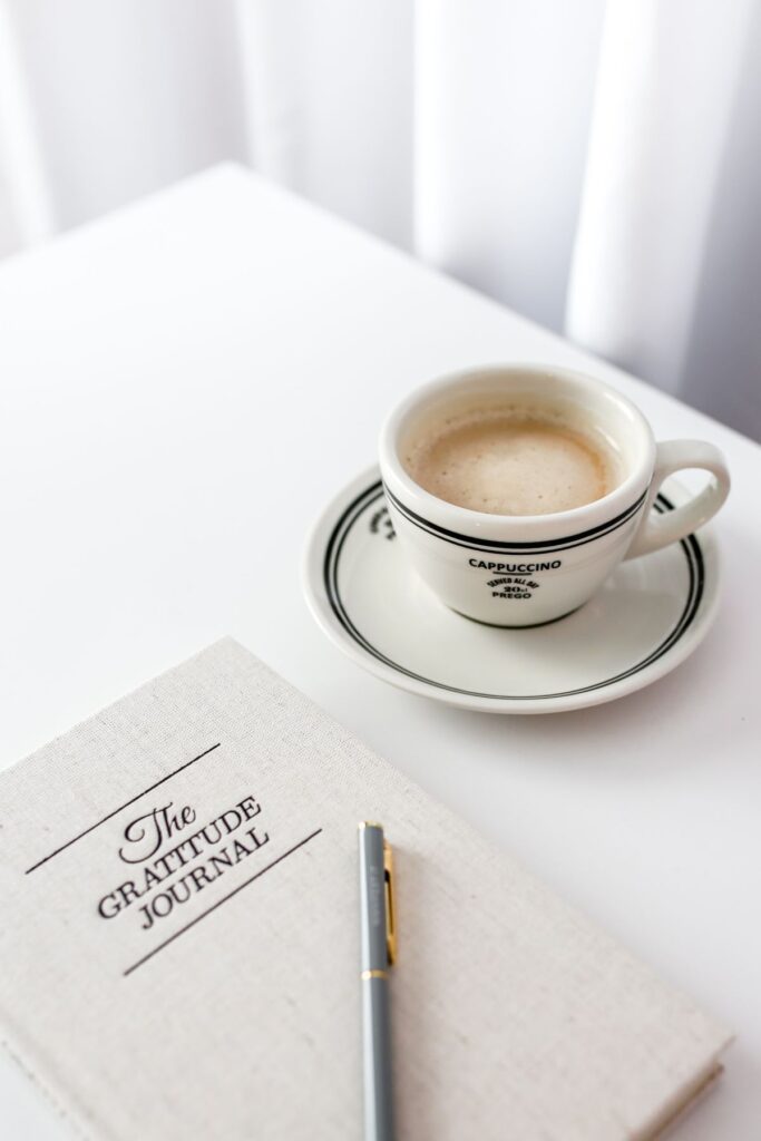 Coffee and gratitude journal flat lay, representing daily lifestyle habits that affect hormones