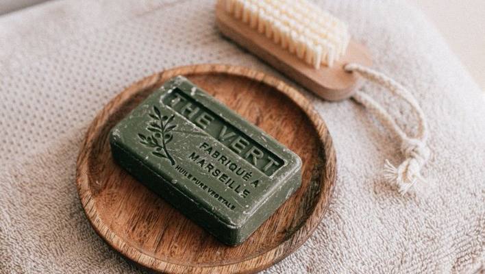 Natural soap and brush arranged on a folded towel for a gentle personal hygiene routine