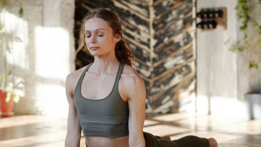 A woman gently stretching on a yoga mat, practicing calm pelvic floor relaxation for interstitial cystitis relief