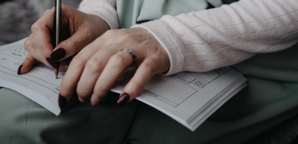 woman tracking her period and hormone symptoms in a journal