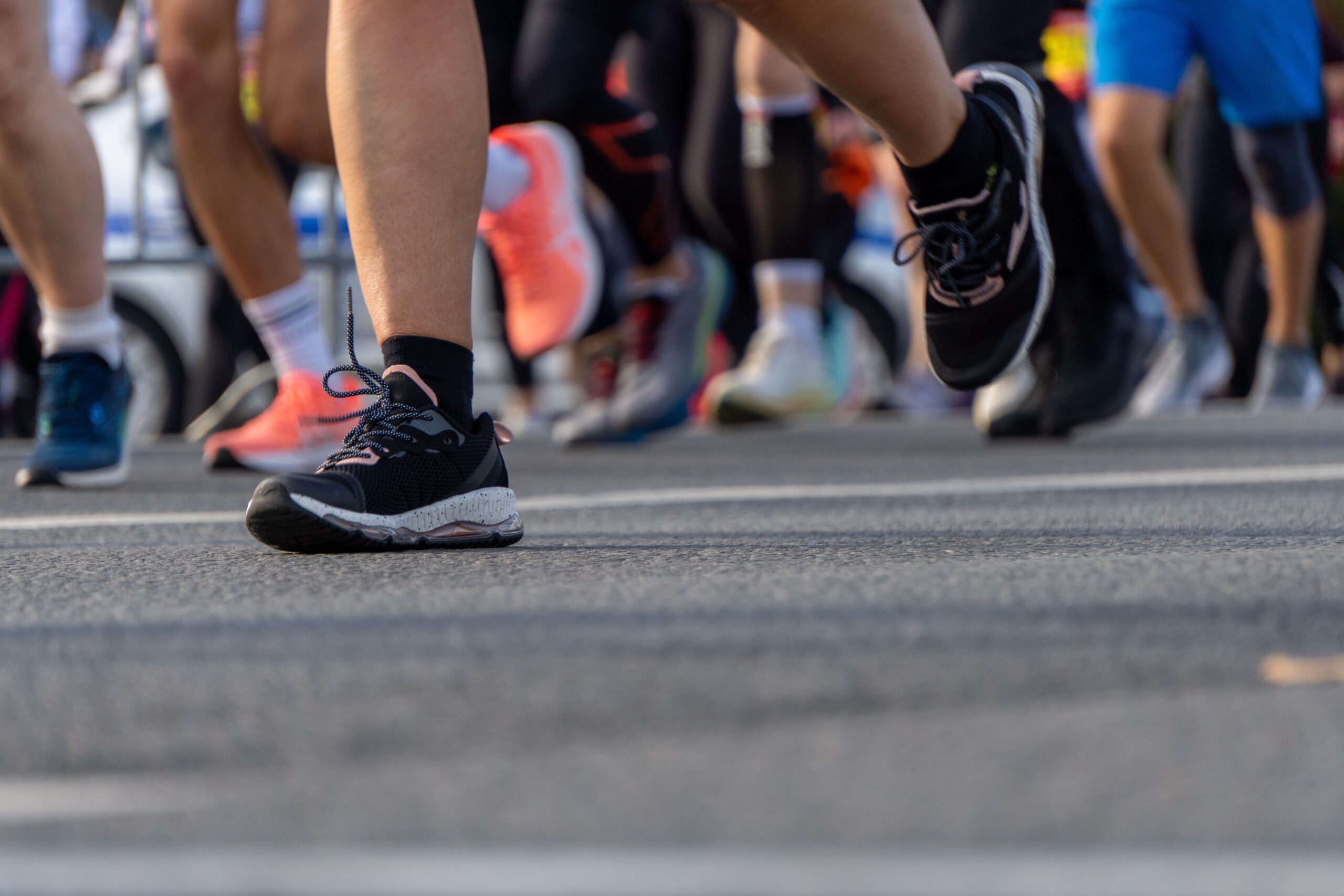 Runners' legs and shoes in motion on a road