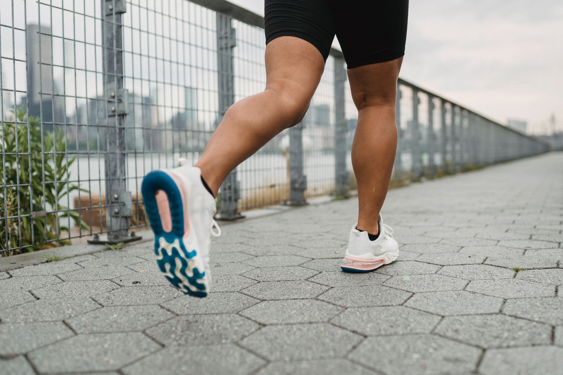 Person jogging on a paved path, shown from the waist down