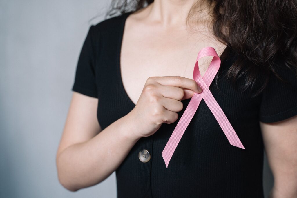 Woman holding a pink ribbon for breast cancer awareness