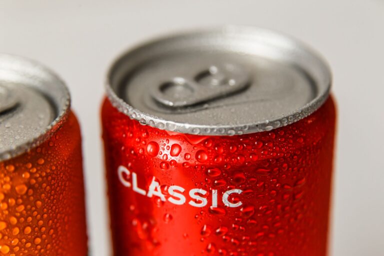Close-up of cold red cans of drink covered in condensation droplets