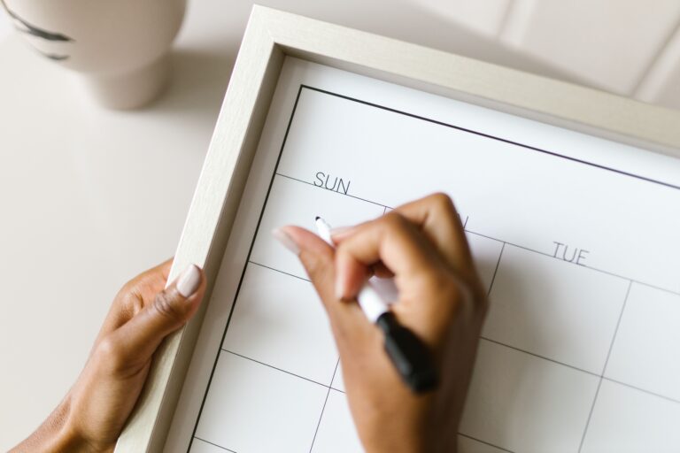 Woman marking dates on a wall calendar to track her menstrual cycle and ovulation window