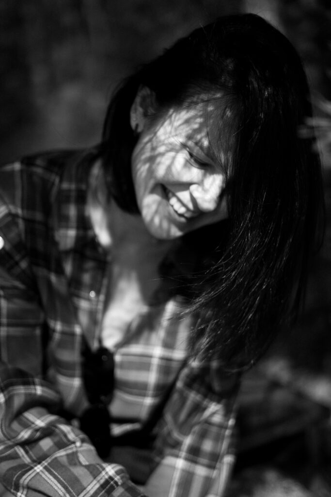 Woman smiling warmly in soft natural light, representing everyday wellbeing and hormone health
