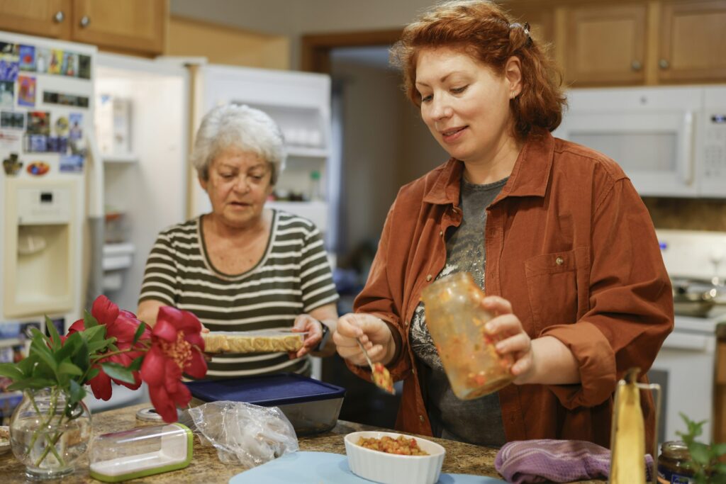 Two women preparing a healthy meal together in a home kitchen, reflecting mindful eating during an intermittent fasting window