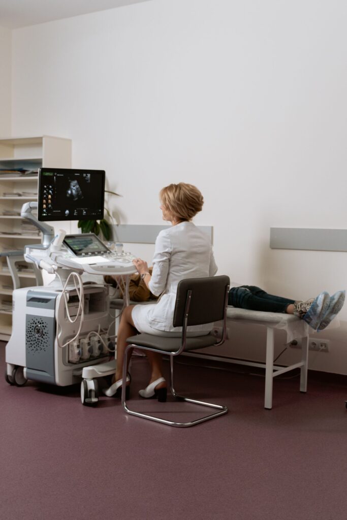 Doctor performing an ultrasound scan on a pregnant woman during prenatal care